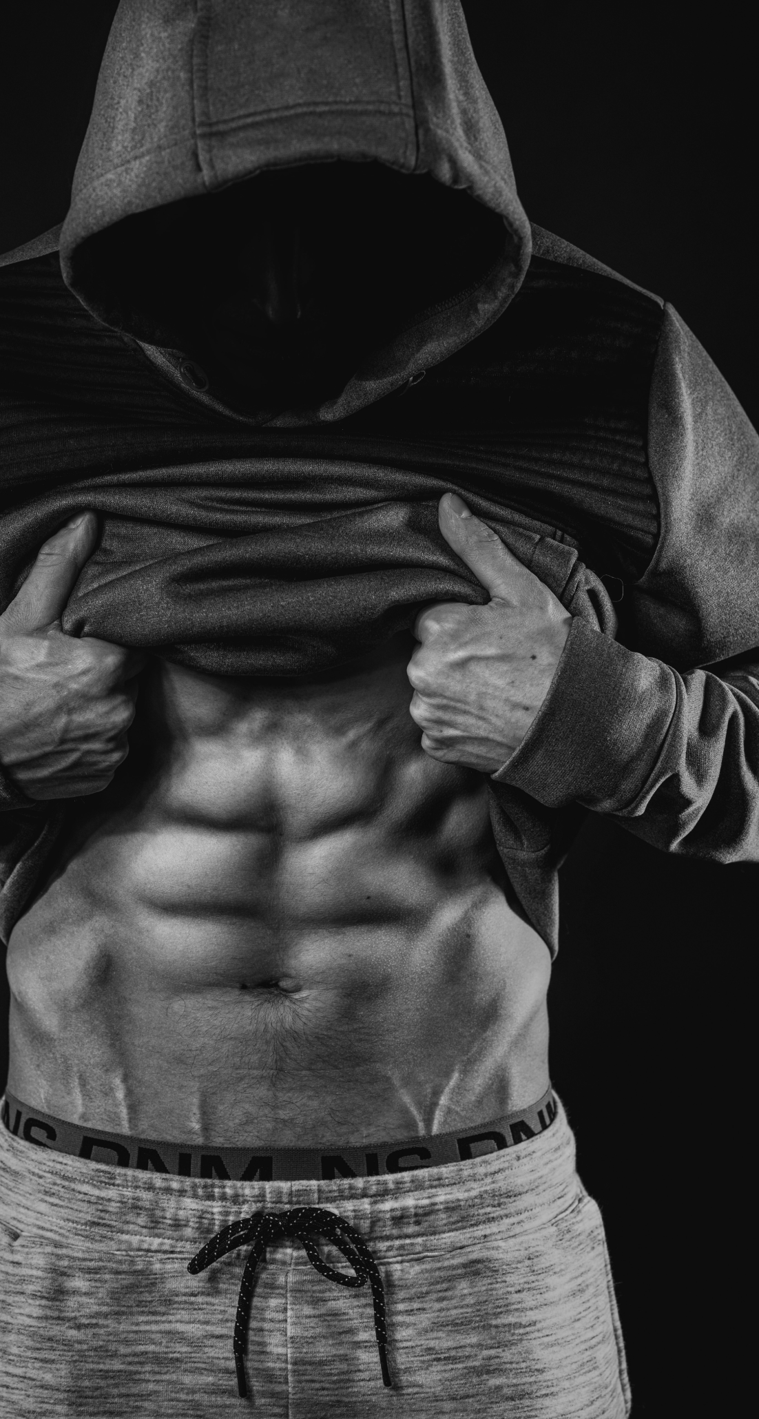 Man lifting shirt to reveal abs